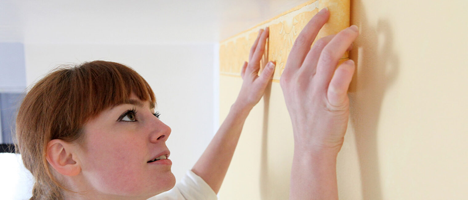 Malerin bei der Arbeit an der Wand Malerin bei der Arbeit an der Wand
